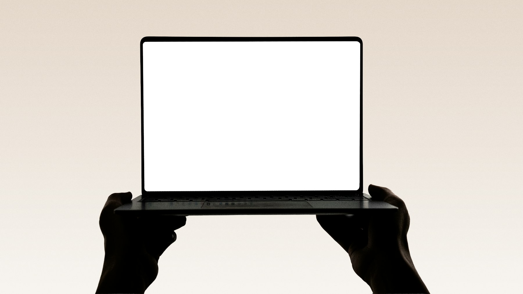 Laptop mockup held in a clean creative studio setting