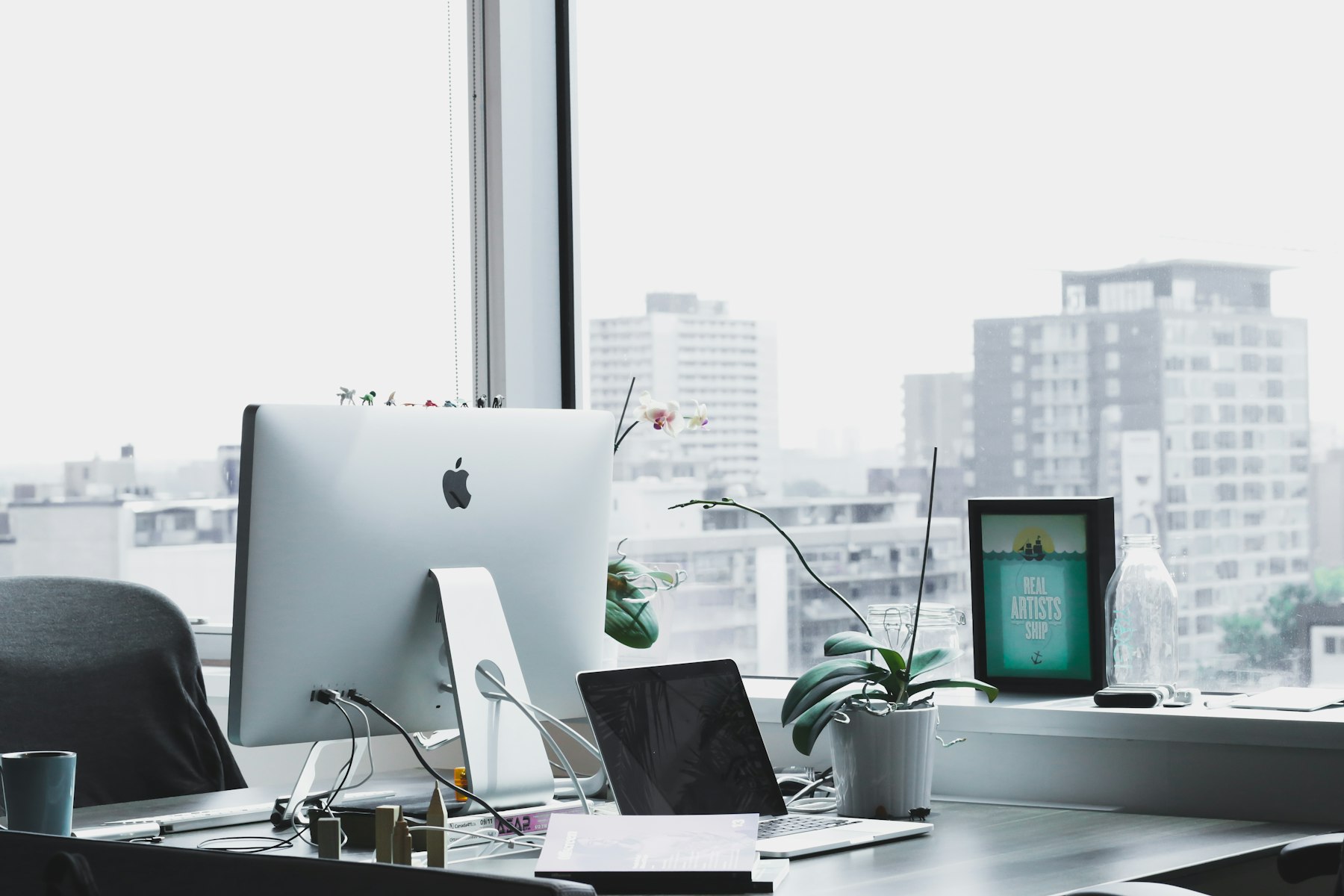 Premium creative studio workspace with laptop, design tools, and warm natural light